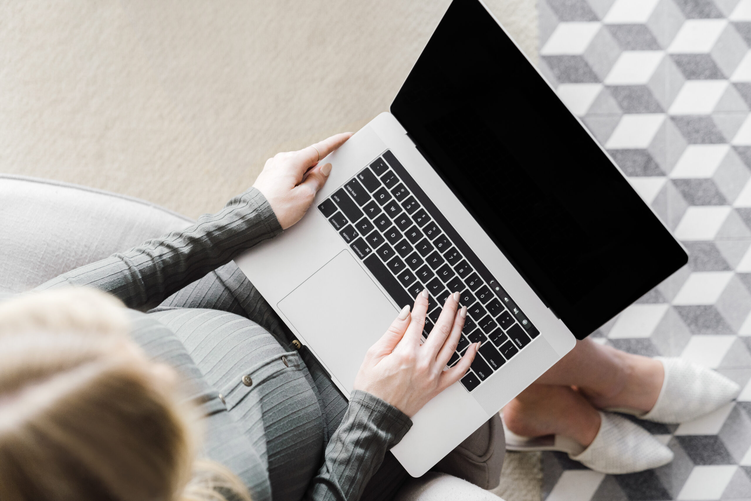 Woman in green shirt sitting working on laptop